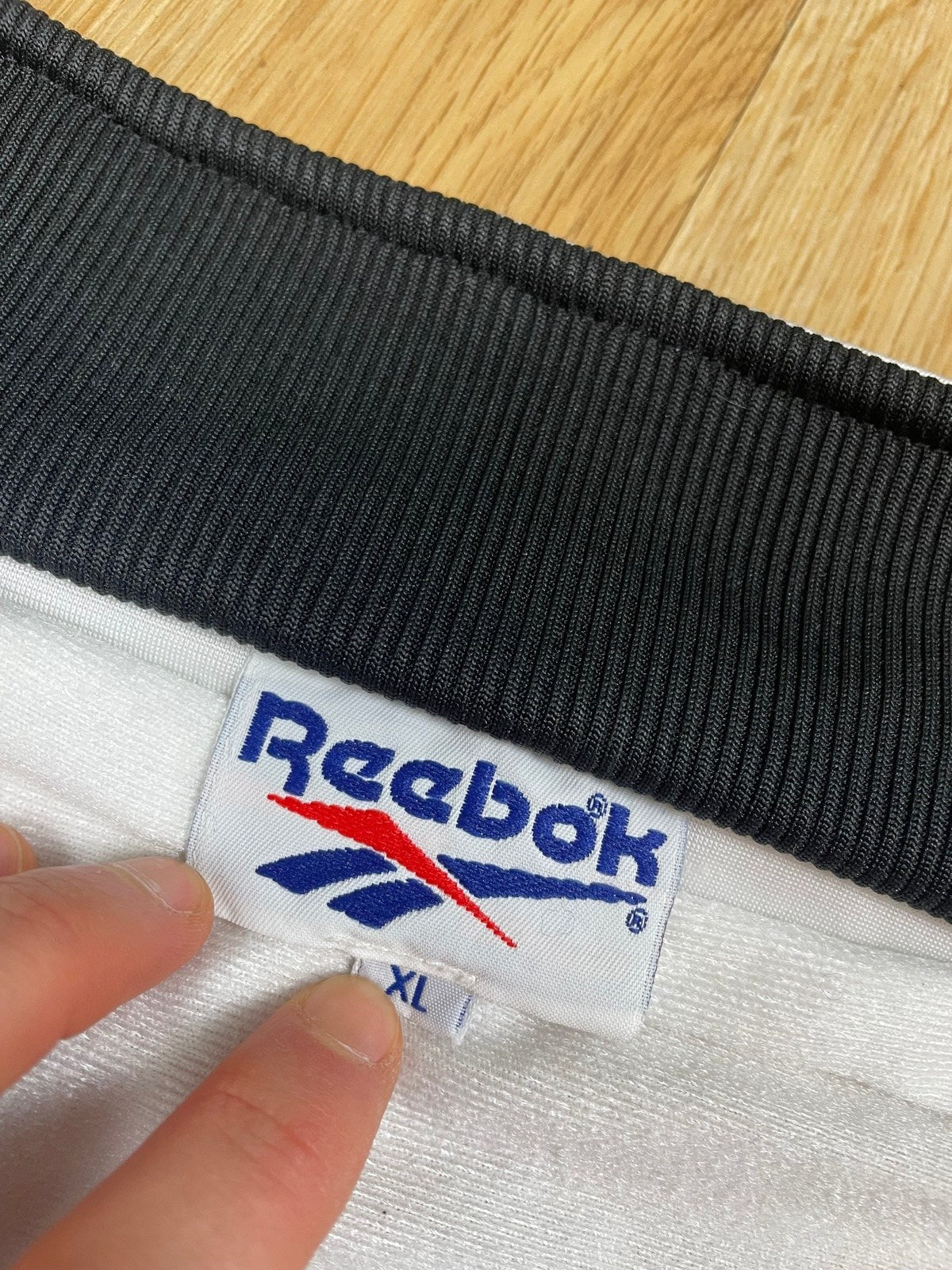 Vintage Reebok Trainingsjacke T-Shirt Weiß/Schwarz/Blau XL - Leichte und Sportliche Herren Jacke Vintage Klamotten, Secondhand Klamotten, Retro Mode, Nachhaltige Mode, Einzigartige Stücke, Zeitlose Mode, Umweltfreundliche Kleidung, Stilvolle Secondhand Mode, Hochwertige Vintage Kleidung