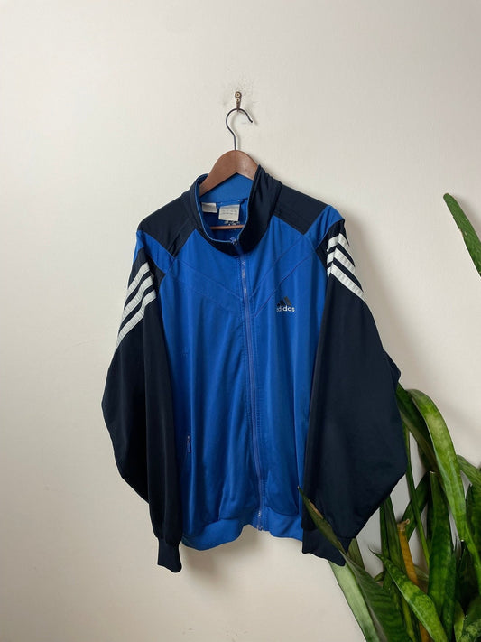 Vintage Adidas Trainingsjacke Blau/Schwarz XL - Sportliche und Bequeme Jacke Vintage Klamotten, Secondhand Klamotten, Retro Mode, Nachhaltige Mode, Einzigartige Stücke, Zeitlose Mode, Umweltfreundliche Kleidung, Stilvolle Secondhand Mode, Hochwertige Vintage Kleidung